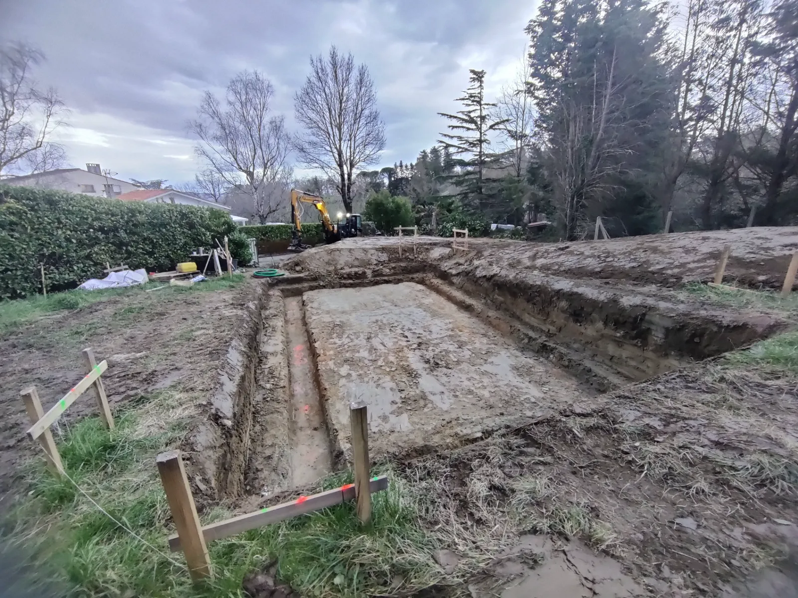Creusement de fondations au crépuscule sur un chantier de maison individuelle